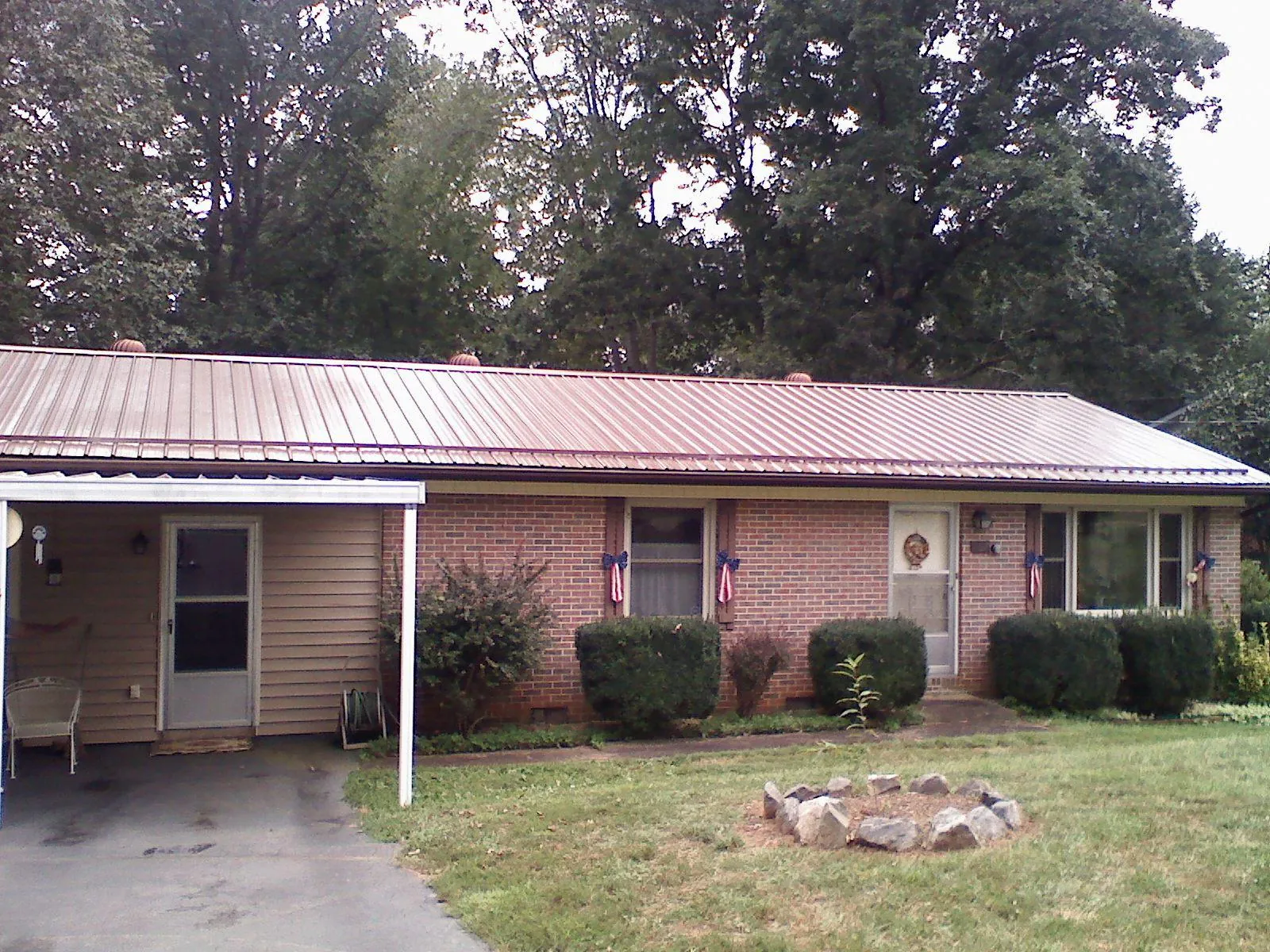 Bronze metal roof and carport on a brick ranch home — Roof Repair work by our crew in Evansdale