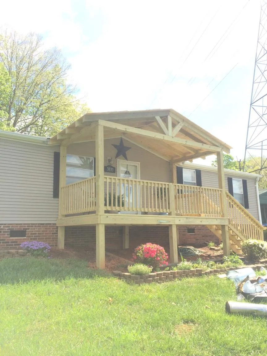 New gabled porch roof and deck railing added to a ranch home in Evansdale